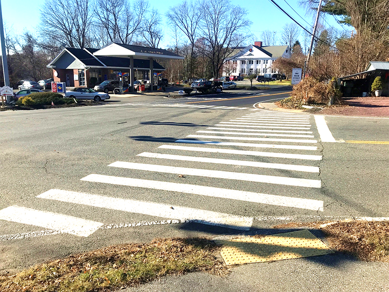 Figure 7 - View across Library Hill Road of Northwest Intersection Corner. Image shows a crosswalk leading to the former One Main Street Studio florist in the foreground and the Stow Building Department on the south side of Great Road (Route 117) in the background. Figure 7 - View across Library Hill Road of Northwest Intersection Corner. Image shows a crosswalk leading to the former One Main Street Studio florist in the foreground and the Stow Building Department on the south side of Great Road (Route 117) in the background.